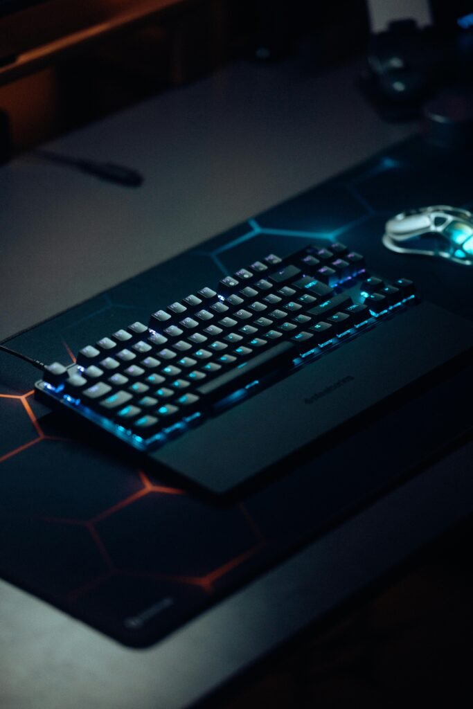 Mechanical keyboard with RGB lighting on a dark gaming setup, perfect for tech enthusiasts.